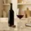 Botol wine merah terbuka dan gelas kristal di atas meja marmer dengan vacuum wine stopper