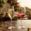 Dua gelas kristal berisi wine merah dan sparkling white wine non-alkohol di atas meja marmer mewah